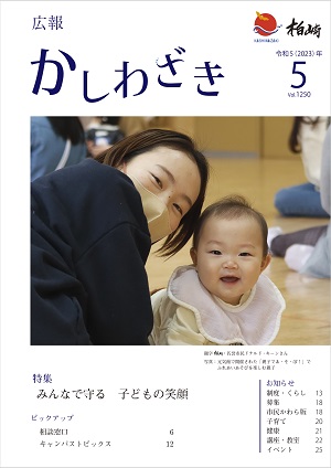 広報かしわざき2023年5月号の表紙：カメラをみて笑顔をみせる赤ちゃんとお母さん