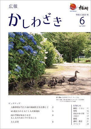 広報かしわざき2023年6月号の表紙：柏崎・夢の森公園の園路を歩くカモの親子たち。園路の左わきには青色や白色、薄ピンク色のアジサイが咲いています