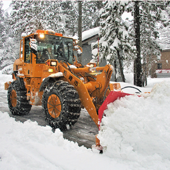 写真：道路に積もった雪を除雪する大型ブルドーザー