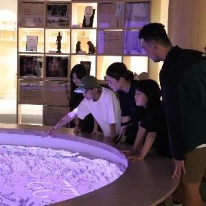 写真：西山ふるさと館内で投影されるプロジェクションマッピングを指さす男の子