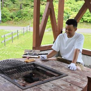 写真：バーベキューハウスで火おこしをするお父さん