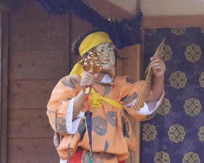 写真：右手に鈴を、左手に扇を持った、神楽舞の一場面。