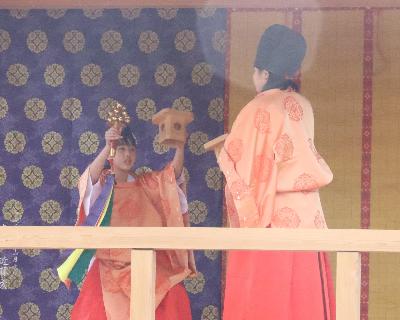 写真：2人の女の子が鈴と三宝を持つ神楽舞の一場面。