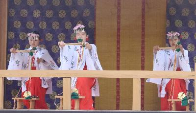 写真：白い着物に赤い袴をはいた3人の女の子が、腰を軽く落とし両手を前に出した一場面