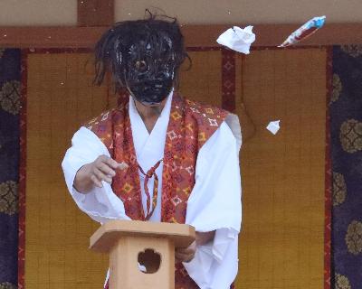 写真：三宝に載せた餅やお菓子を巻く、神楽舞の一場面。