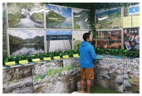 写真：水道やダムに関する写真などを展示している水のふるさと展示室を見学する辰尾くん
