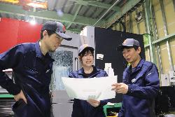 写真：2人の男性社員と図面を見ながら話し合う細貝さん（中央）