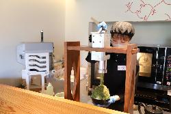 写真：抹茶味のかき氷の上に抹茶のモンブランクリームを絞り出している押見さん