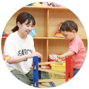 写真：ボールを転がして遊ぶおもちゃを楽しむ親子