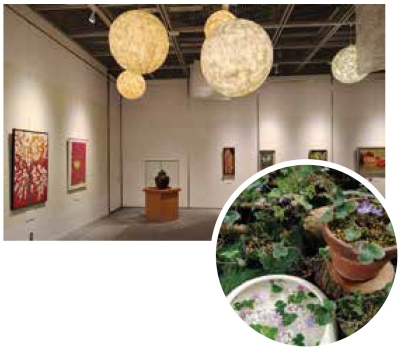 写真：花がテーマの絵画を展示した会場と、雪割草の鉢植えと手水鉢の2つの写真があります。作品が展示された会場には、天井から門出和紙を使用した照明が吊り下げられ、会場を優しい光で包んでいます。