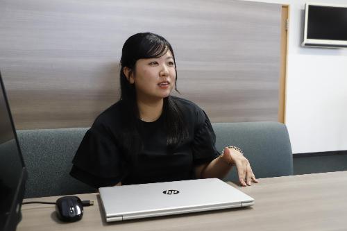 写真：社内の会議スペースでインタビューに応じる田川さん