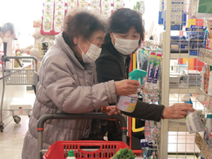 写真：利用者の買い物に付き添うボランティアの女性