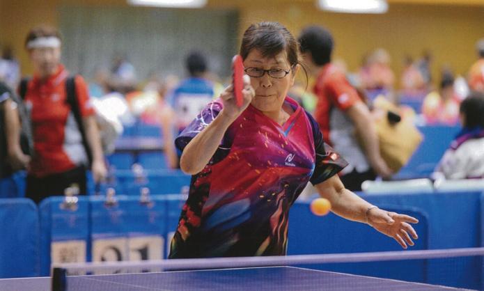 卓球の競技中にラケットを右手に持ちスマッシュを打ち込んだ様子の村山さんの写真