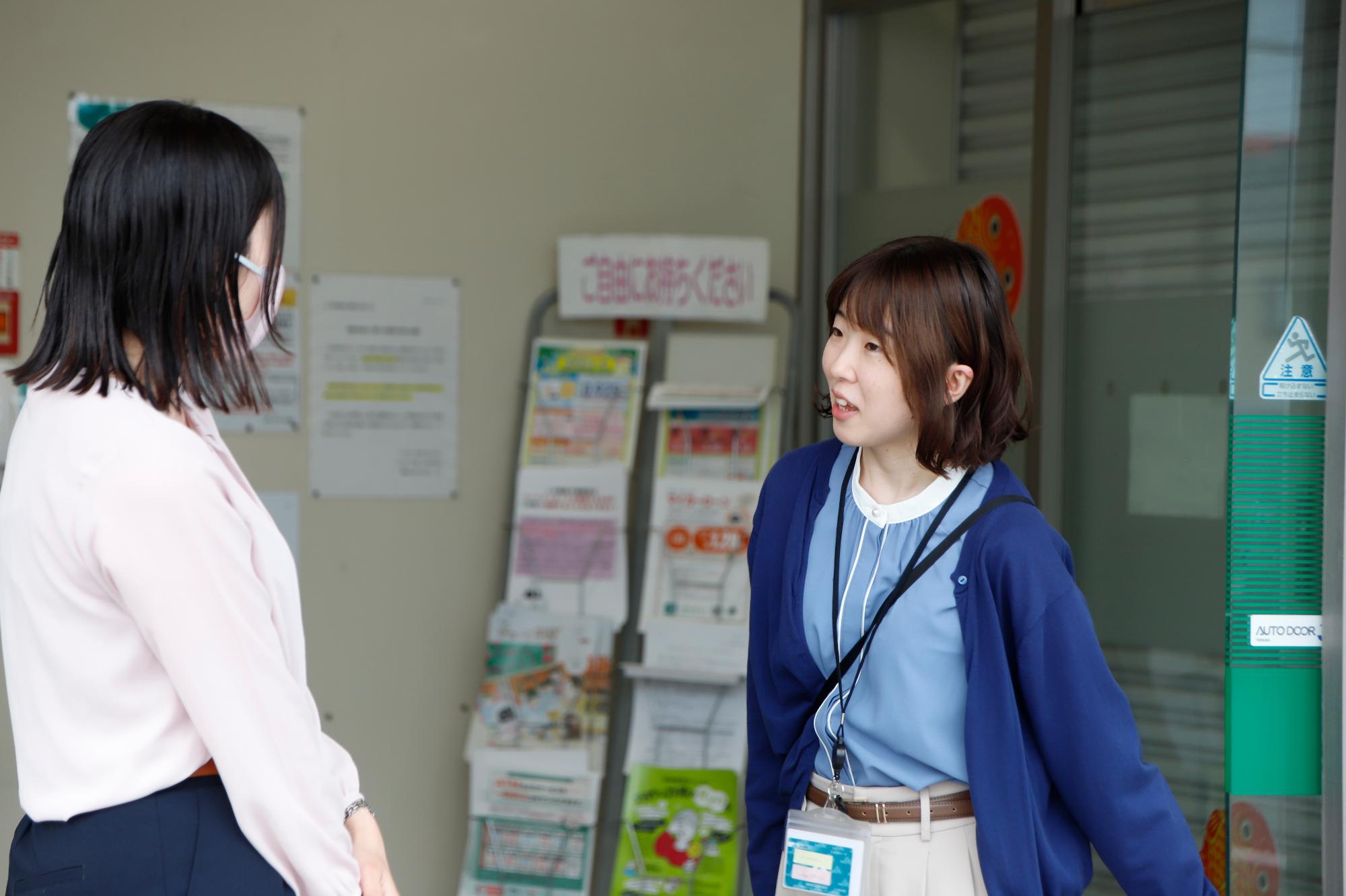 写真：事務所の前で対応する尾崎さん
