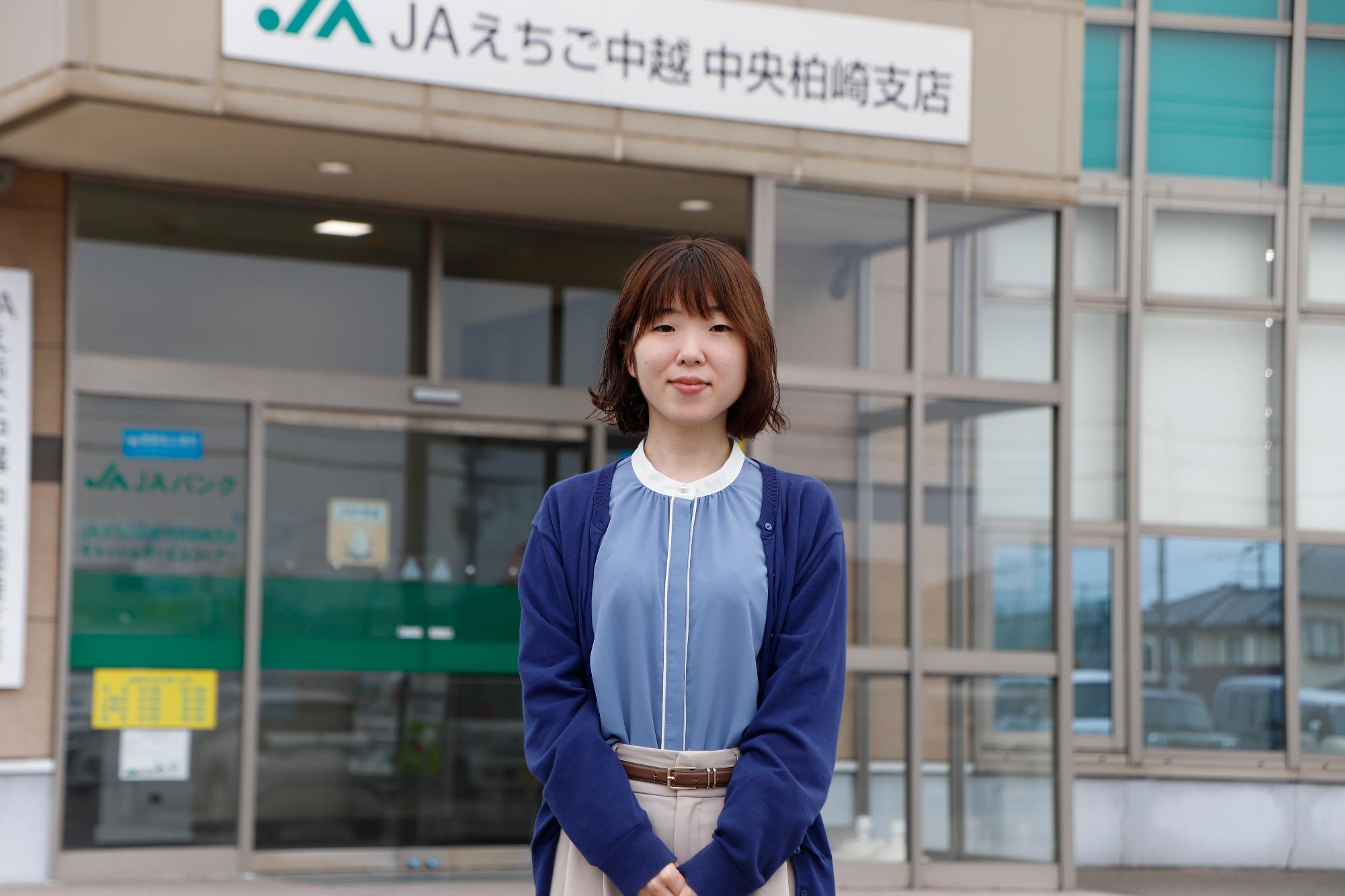 写真：JAえちご中越中央柏崎支店の事務所前に立つ尾崎さん