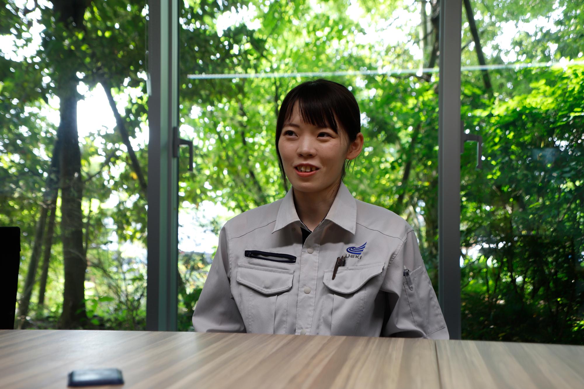 写真：社内で座ってインタビューを受ける橘さん