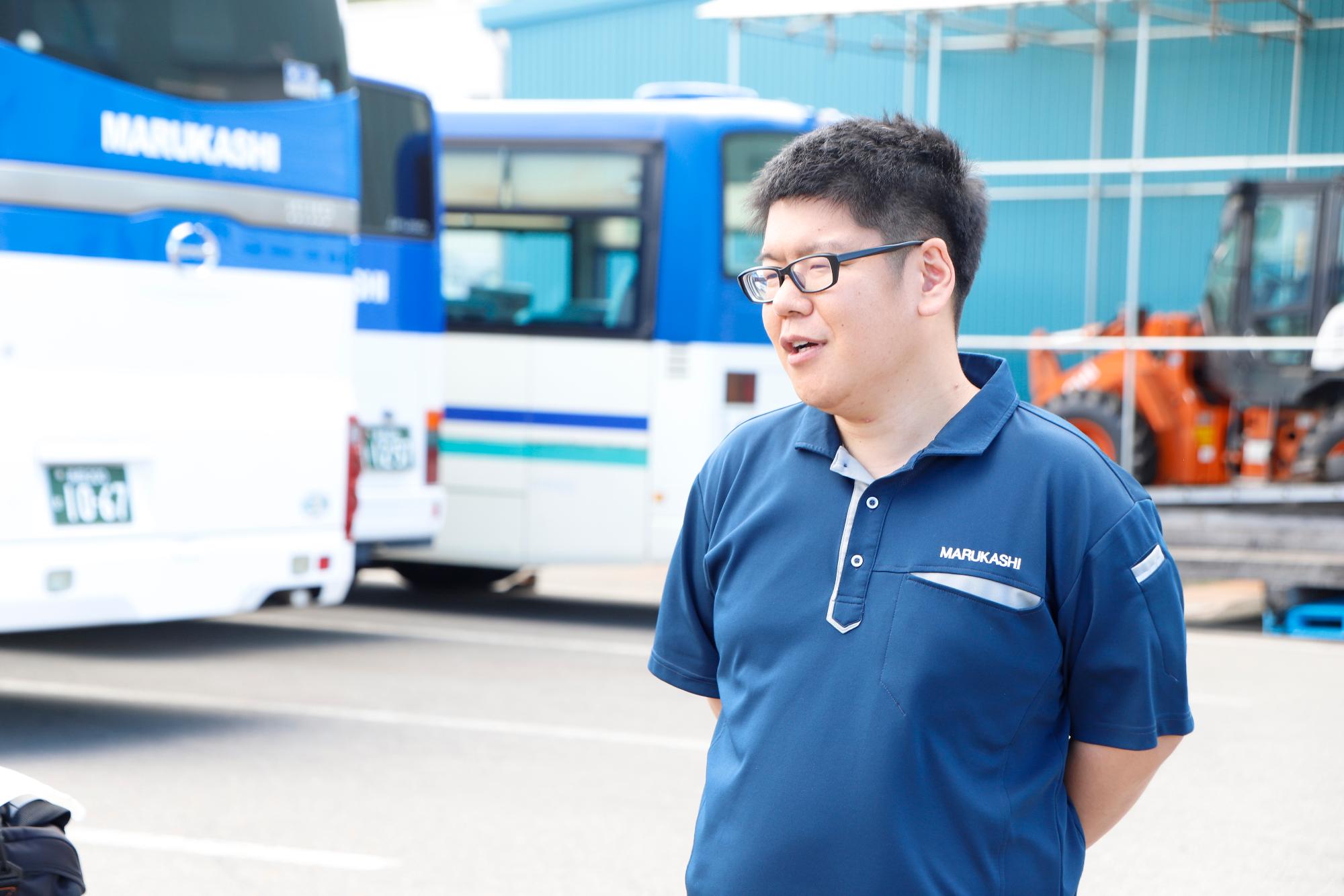 写真：職場の駐車場でインタビューを受ける橋本さん