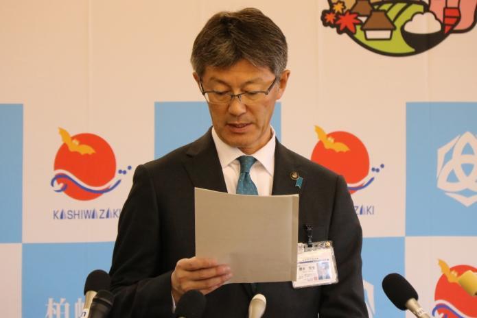 東電の報告書を見ながら記者からの質問に答える市長の写真