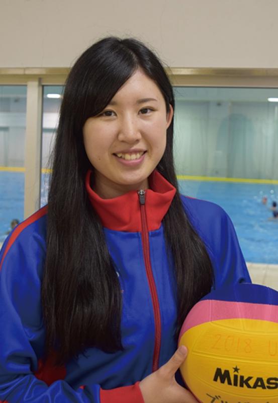 青いジャージを着て手にはボールを持っている笑顔の梅田 優子さんの写真